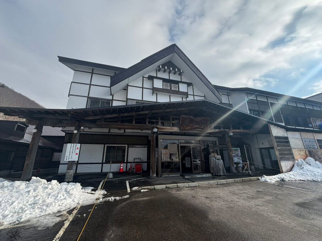 Front view of the traditional wooden entrance of Sukayu Onsen, a historic hot spring in Aomori, Japan.