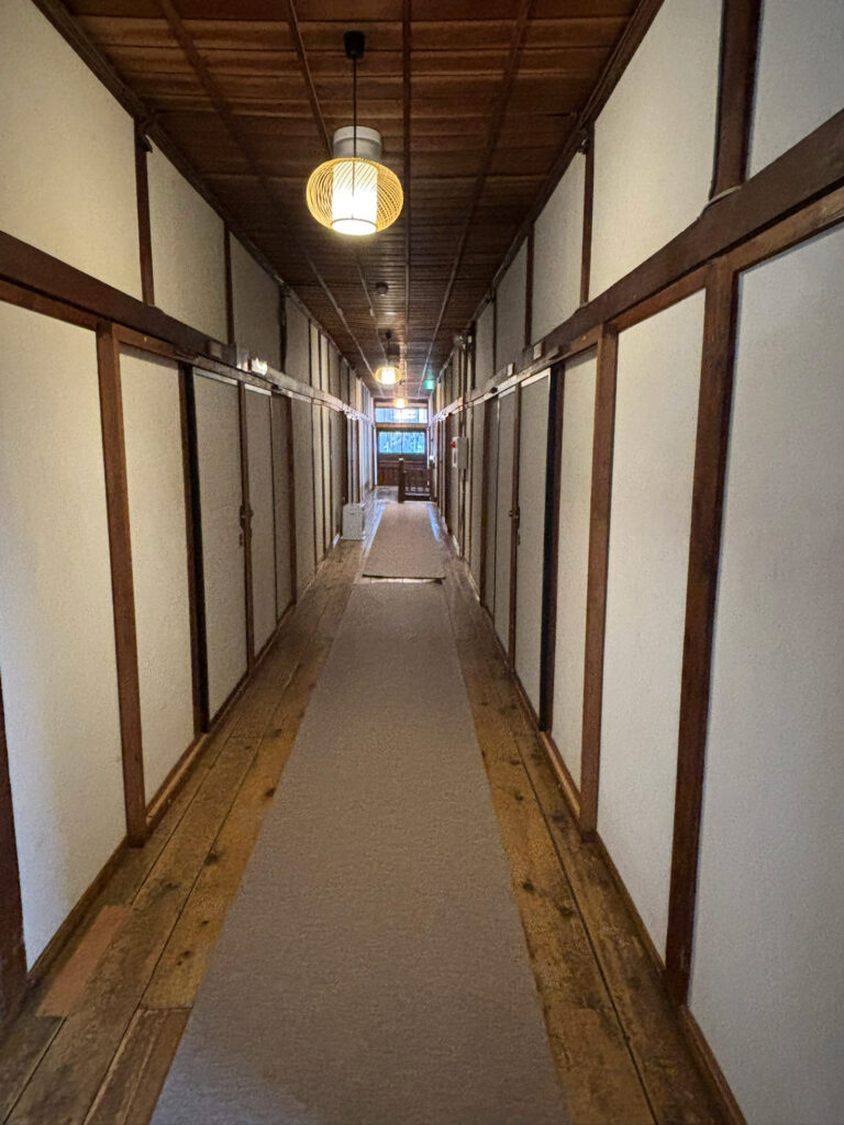 Long wooden hallway inside Sukayu Onsen with nostalgic Japanese architecture