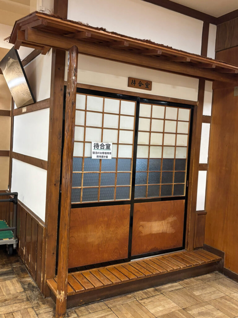 Luggage storage shelves located in front of the front desk at Sukayu Onsen, where guests can leave suitcases before check-in