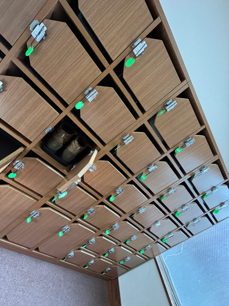 Shoebox area at Sukayu Onsen with wooden lockers and guest winter boots