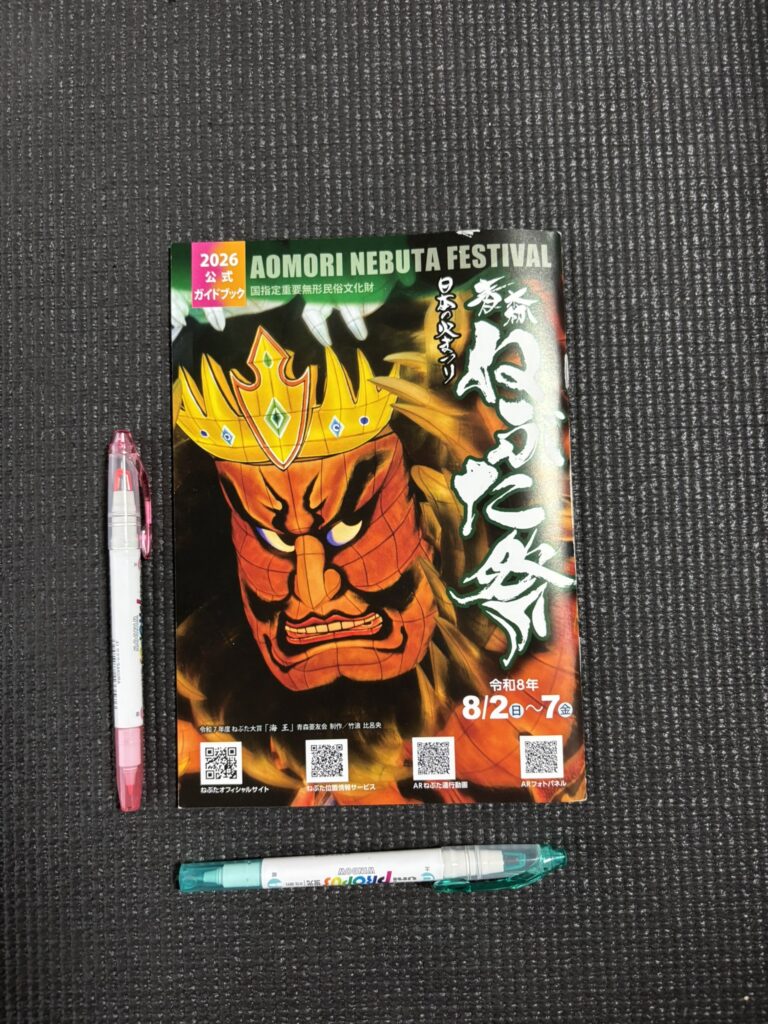 2026 Aomori Nebuta guidebook beside two pens